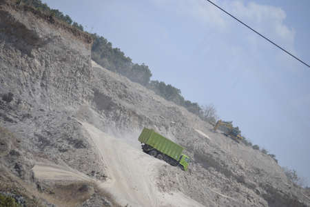green truck in the sand mining area. the condition looks dry and dusty because it is in the dry...