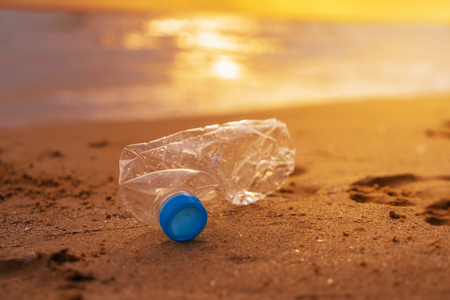 The plastic bottle  on the beach at the sunsetの写真素材