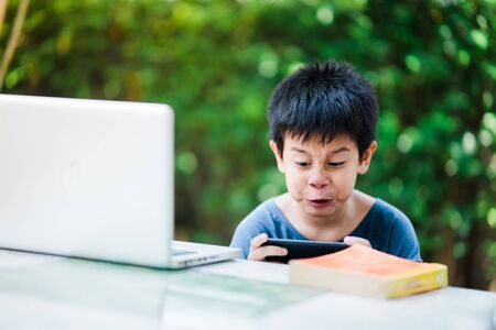 The boy playing game on smartphone,The boy didn't intend to read,The boy crazy while playing game on the smartphone,の写真素材