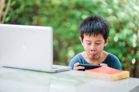 The boy playing game in smartphone,The boy didn't intend to read,The boy crazy while playing game in...