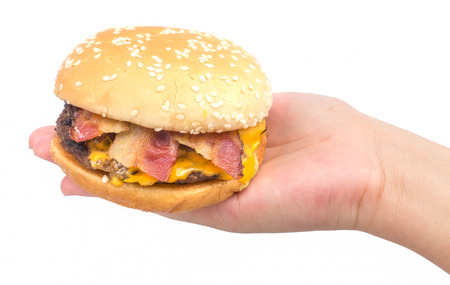 Female hand holding burger in isolate background.の写真素材