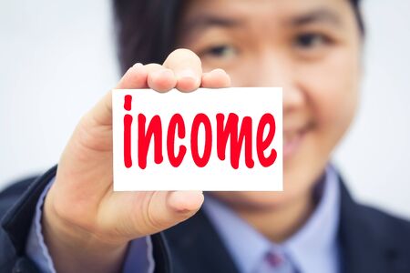 Businesswoman holding card with income message.の写真素材