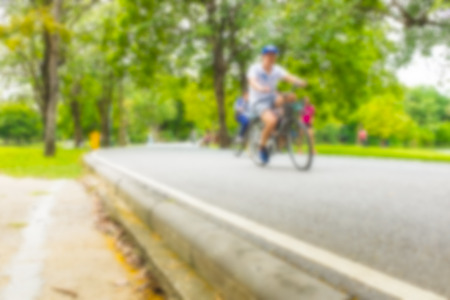 Colourful blurred image of people ride bicycle and jogging in the parkの写真素材