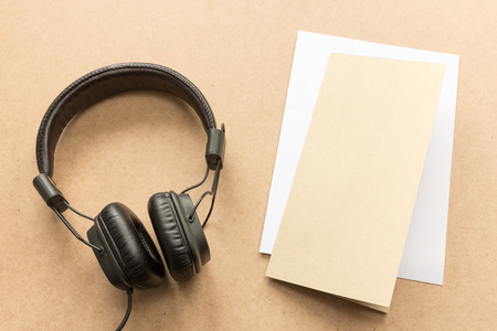 Headphone with brown and white paper note on wood desk in music studio.の写真素材