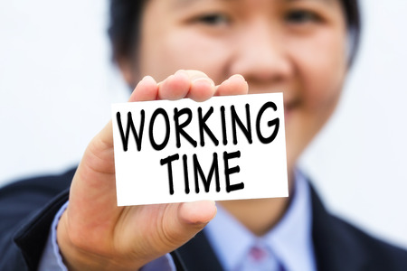 Businesswoman holding card with WORKING TIME message.の写真素材