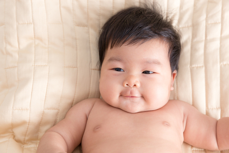 Adorable baby girl lying in the bed.の写真素材