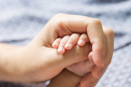 Baby hand holding finger mom. (Selected focus)の写真素材