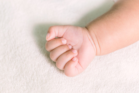Baby hand on white blanket in vintage tone for background.の写真素材