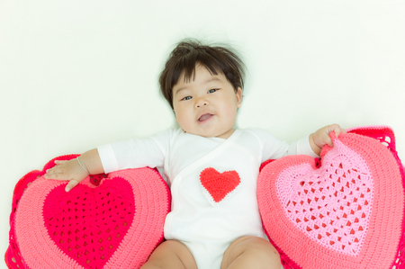 Heart pillow with adorable girl for valentine concept background.の写真素材