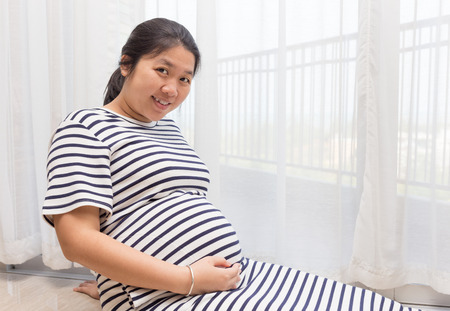 Pregnant woman holding her belly with copy space.の写真素材