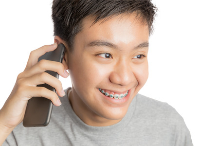 Young man smiling and happy use smartphone. Handsome young man multiracial asian / caucasian model Isolated background.の写真素材