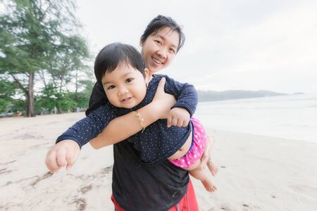 Mom and child relax and happy on the beach.の写真素材
