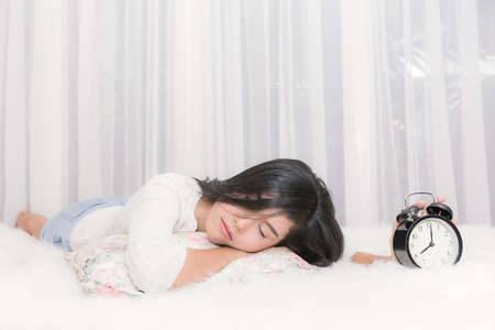 Woman wake up early after hard working in the bedroom.の写真素材