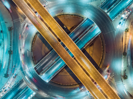 Aerial view highway road intersection at night for transportation, distribution or traffic background.の写真素材