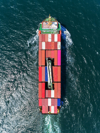 Aerial view small size container ship full speed and working crane bridge loading container for...