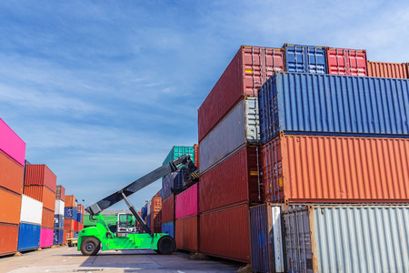 Forklift truck working in container warehouse with beautiful sky for logistics shipping, import...