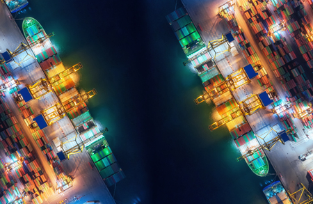 Aerial top view container ship at sea port and working crane bridge loading container for import...