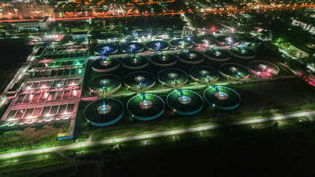 Aerial view water treatment plant at night with cityscape for environment concept.の写真素材