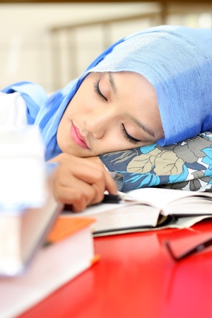 A young muslim woman sleeping while reading a book の写真素材