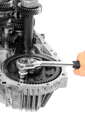 Hand with ratchet handle and mechanical gear on isolated white background の写真素材