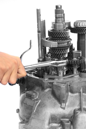 Hand with ratchet handle and mechanical gear on isolated white background の写真素材