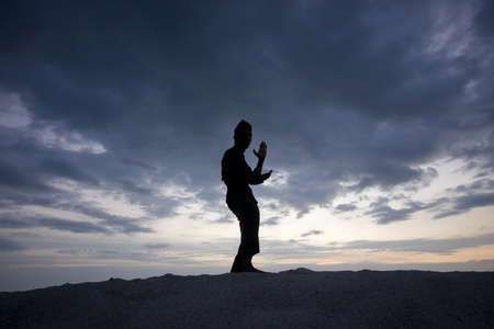 Silhouette of young boy performing a pencak silat, Malay traditional discipline martial artの写真素材