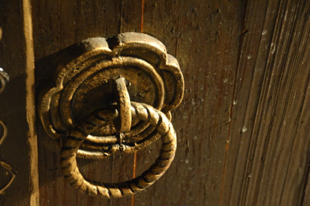 Old wooden door with a brass knocker, closeup of photoの写真素材