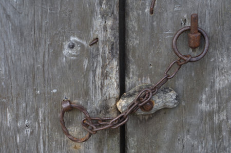 Old rusty chain on a wooden door, close-up, background