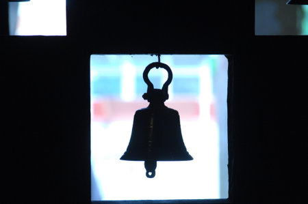 Silhouette of a bell in the dark, at night.の写真素材