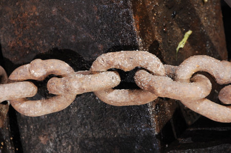 Rusty chain on an old iron billet, closeup of photo