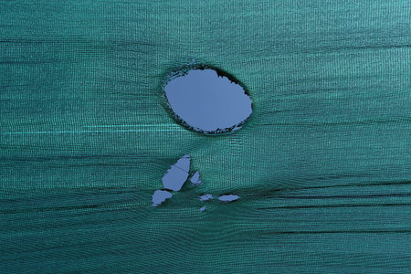 Broken window on blue fabric background. Close-up of broken window.の写真素材