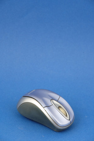 Wireless computer mouse on blue background with copy space for text.の写真素材