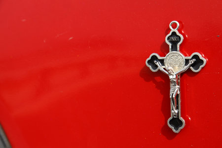 Detail of a classic car with a cross on a red background