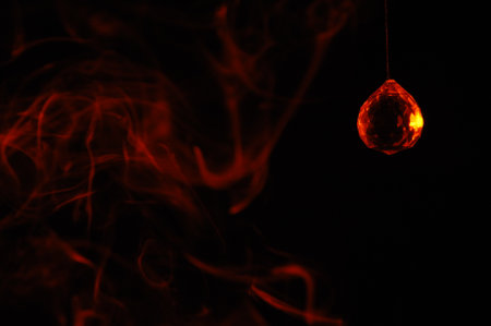 Abstract background of red smoke on a black background with a light bulbの写真素材