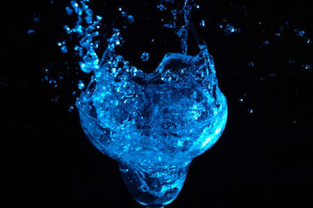 blue water splash on black background. close up of water splash.の写真素材