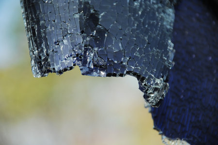 Broken glass close-up on a background of blue sky.