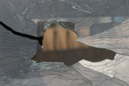 Broken glass with a hole in the shape of a human head
