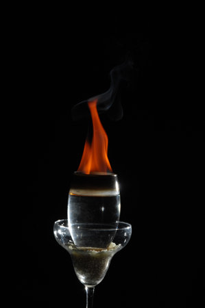 Burning wine glass on black background, close-up image.の写真素材