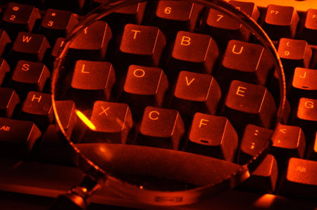 Computer keyboard with magnifying glass and word love. Selective focus.の写真素材