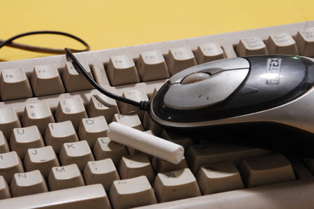 Computer keyboard with mouse and chalk on yellow background, close-upの写真素材