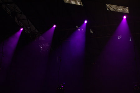 Purple stage lights at a concert in a dark room, closeup of photo