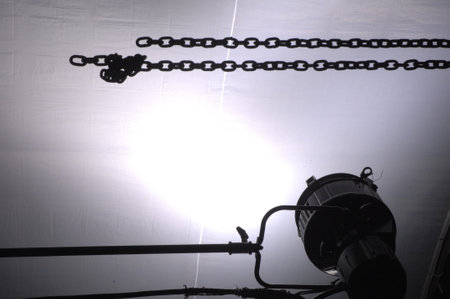 Industrial background with heavy chain and light, closeup of photoの写真素材