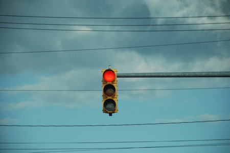 Traffic light on a background of blue sky with white clouds.
