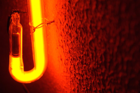 Close-up of a fluorescent light bulb with a red glow in it.の写真素材