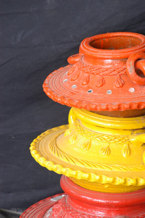 Colorful pottery on black background, closeup of photo.