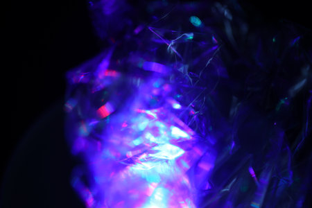 abstract background with purple and blue glittering lights on black backdrop