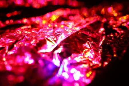 Abstract background of red and pink shiny foil. Close up. Selective focus.の写真素材