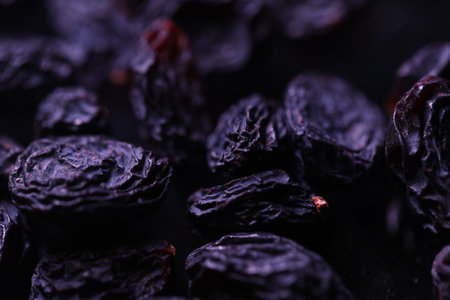 Black raisins on a dark background close-up macro photographyの写真素材