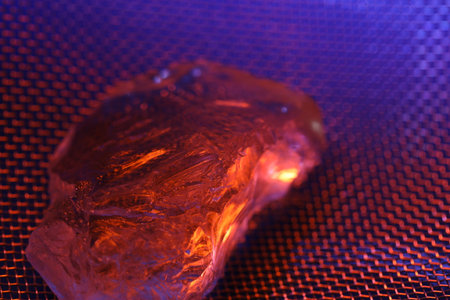 Amber on a metal grid close-up. Macro photo.の写真素材
