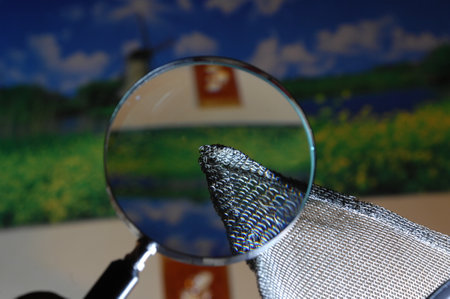 Magnifying glass on a blurred background of a windmill. Close-up.の写真素材